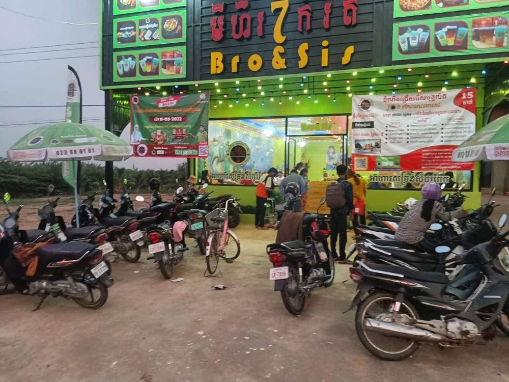 Customers and motorbikes outside a Bro & Sis branch